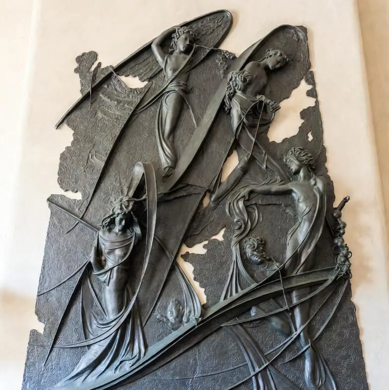 Чавунна скульптура жіночої постаті з квітами на тлі парку. Якісний скульптурний декор з чавуну для ландшафтного дизайну.